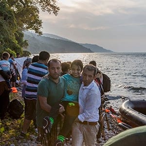 16-year old Syrian refugee Nujeen Mustafa, who is a wheelchair user with cerbal palsy, smiles as she is lifted from the shore-line to the road having landed on the Greek island of Lesbos after a very rough crossing from Turkey. She and her older sister Nisreen had made the journey along with 40 or so other Syrians. They left their home in Aleppo with their parents over 2 years ago and had been living in Turkey since. The girls had decided to make the journey so that Nogeen could receive better medical attention. After a very rough crossing, which had left most of the passengers cold and terrified, Nogeen seemed extremely calm and happy. A fluent English speaker, when i asked if she had been afraid during the crossing she said “No i enjoyed it. I have never been on a boat before, It was very beautiful. I didn't know if I was going to live or die, but thanks God we are here”. A young Syrian boy looks back towards Turkey after crossing the Aegean along with his family to Greece. In recent weeks huge numbers of refugees, many of them hailing from Syria and Afghanistan have been crossing the Aegean sea from Turkey to Greece. The Island of Lesbos is the main landing point and thousands of people are now clogging the Islands’ main cities and ports as they look for ways to continue their journey onto the mainland and towards the Balkans. The crossings are fraught we danger as boats are overloaded and usually captain-less. (Ivor Prickett)