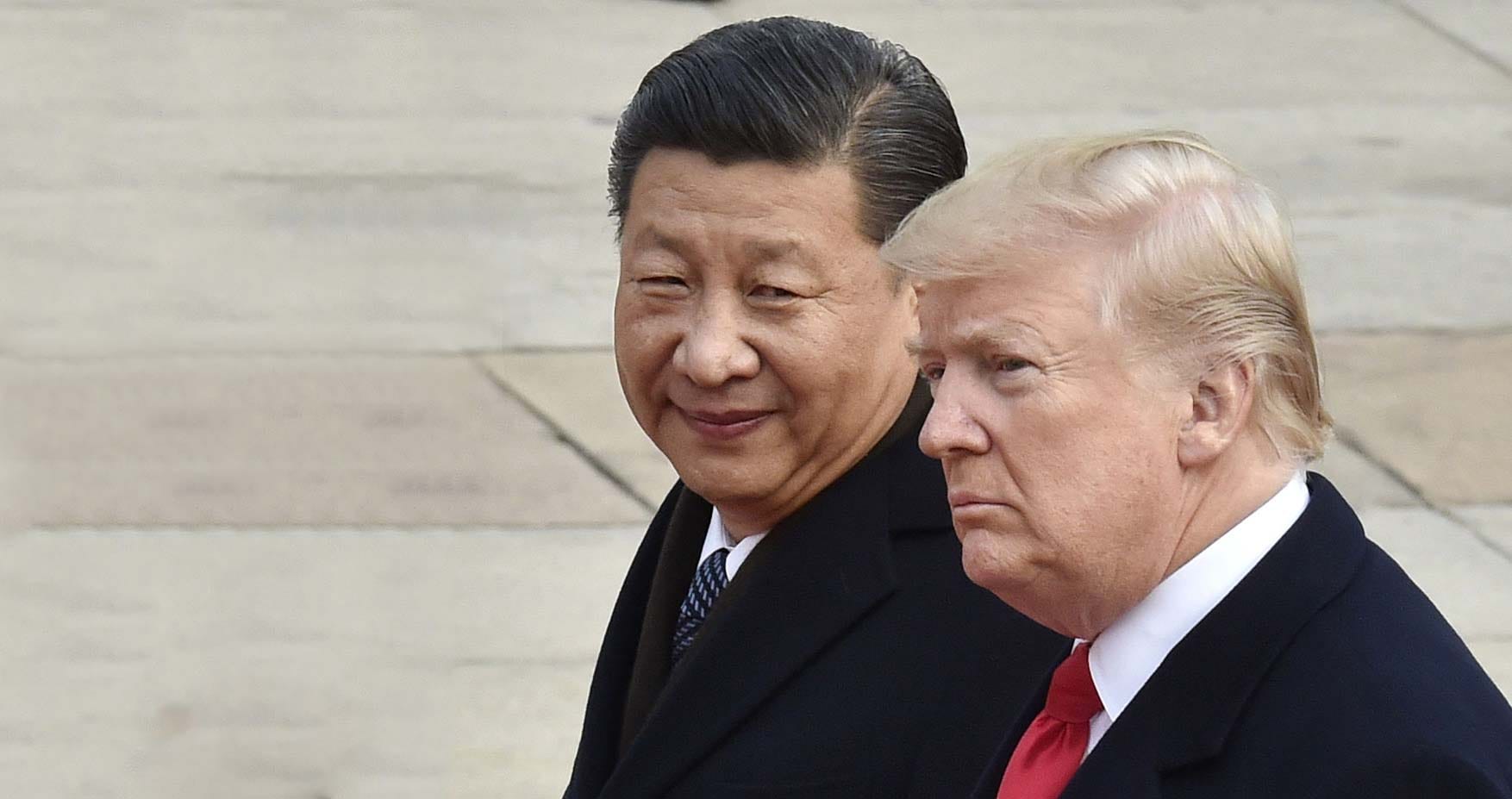 U.S. President Donald Trump (R) and Chinese President Xi Jinping attend a welcome ceremony in Beijing. (Photo by Kyodo News via Getty Images)