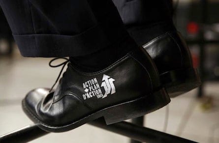 Canada's Finance Minister Flaherty wears the Economic Action Plan logo on his shoes during an interview after delivering the budget on Parliament Hill in Ottawa