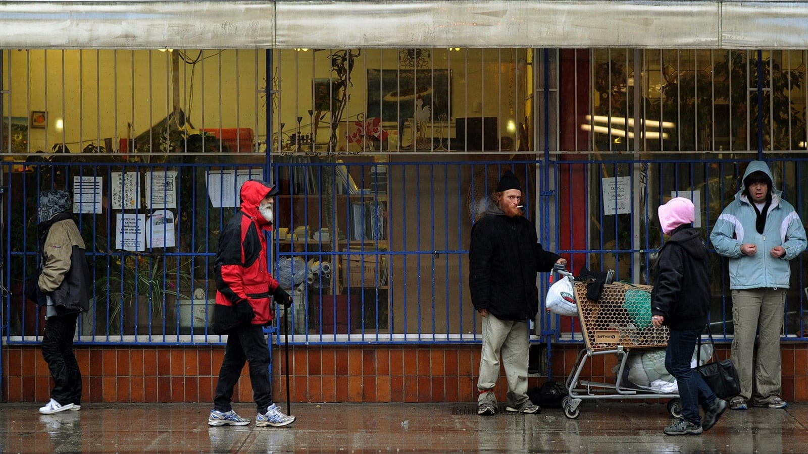 A group of homeless and poor seek shelter from the rain outside a store in the Downtown Eastside area of Vancouver on February 11, 2010. (Mark Ralston/AFP/Getty Images)