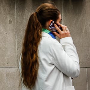 A woman speaks on her phone in front of a Rogers Communications Inc sign before the company's AGM in Toronto