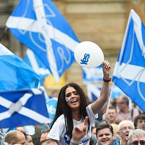 Campaigners wave Scottish Saltires at a 'Yes' campaign rally in Glasgow