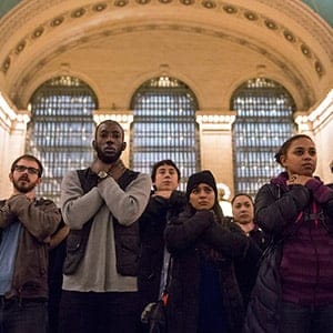 Protesters observe a moment of silence in a chokehold gesture during a march at Grand Central Station for Eric Garner in New York