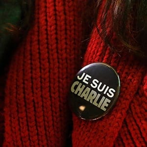 Woman wears a pin during a vigil outside the Consulate General of France to pay tribute to the victims of the suspected Islamist attack on satirical magazine Charlie Hebdo in Paris, in San Francisco