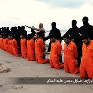 Still image from video shows men purported to be Egyptian Christians held captive by the Islamic State kneeling in front of armed men along a beach said to be near Tripoli