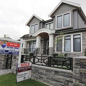 Realtors' signs are hung outside a newly sold property in a Vancouver neighborhood