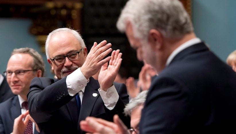 Quebec Finance Minister Carlos Leitao, left, applauds after he presented a provincial budget, Thursday, March 26, 2015 at the legislature in Quebec City. (CP)