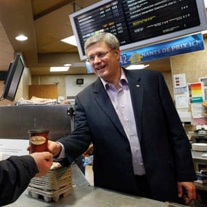 Conservative leader and Canada's Prime Minister Stephen Harper works behind the counter during a campaign stop at a Tim Hortons in Dieppe, New Brunswick April 1, 2011. Canadians will head to the polls in a federal election May 2. Chris Wattie/Reuters