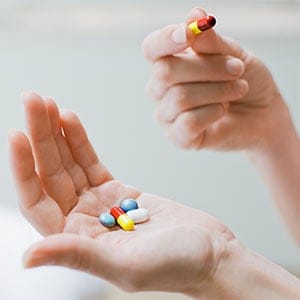 Woman taking vitamins and supplements. Tom Merton/Getty Images