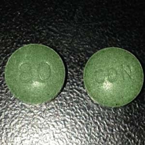 The greenish-marbled tablets look like Oxycontin pills, with "80" stamped on one side and "CDN" on the other, but contain caffeine and fentanyl instead of oxycodone. (Surrey RCMP)
