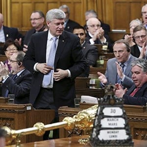 Canada's Prime Minister Stephen Harper stands to vote in the House of Commons on Parliament Hill in Ottawa March 30, 2015. Parliamentarians voted to expand Canada's military mission against Islamic State by launching air strikes against the militants' safe havens in Syria as well as Iraq. (REUTERS/Chris Wattie)