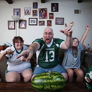 CFL super fan Matt Lalor (centre) and family watching a game in their Alton, Illinois home. (Photograph by Dusty Kessler)