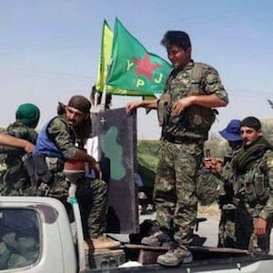 In this photo provided by the Kurdish fighters of the People's Protection Units (YPG), which has been authenticated based on its contents and other AP reporting, Kurdish fighters of the YPG, sit on their pickup in the town of Ein Eissa, north of Raqqa city, Syria, Tuesday, June 23, 2015. Kurdish fighters and their allies have captured an Islamic State group military base in northern Syria under the cover of U.S.-led airstrikes bringing them closer than ever to the extremists de facto capital of Raqqa, activists said Tuesday. (The Kurdish fighters of the People's Protection Units via AP)