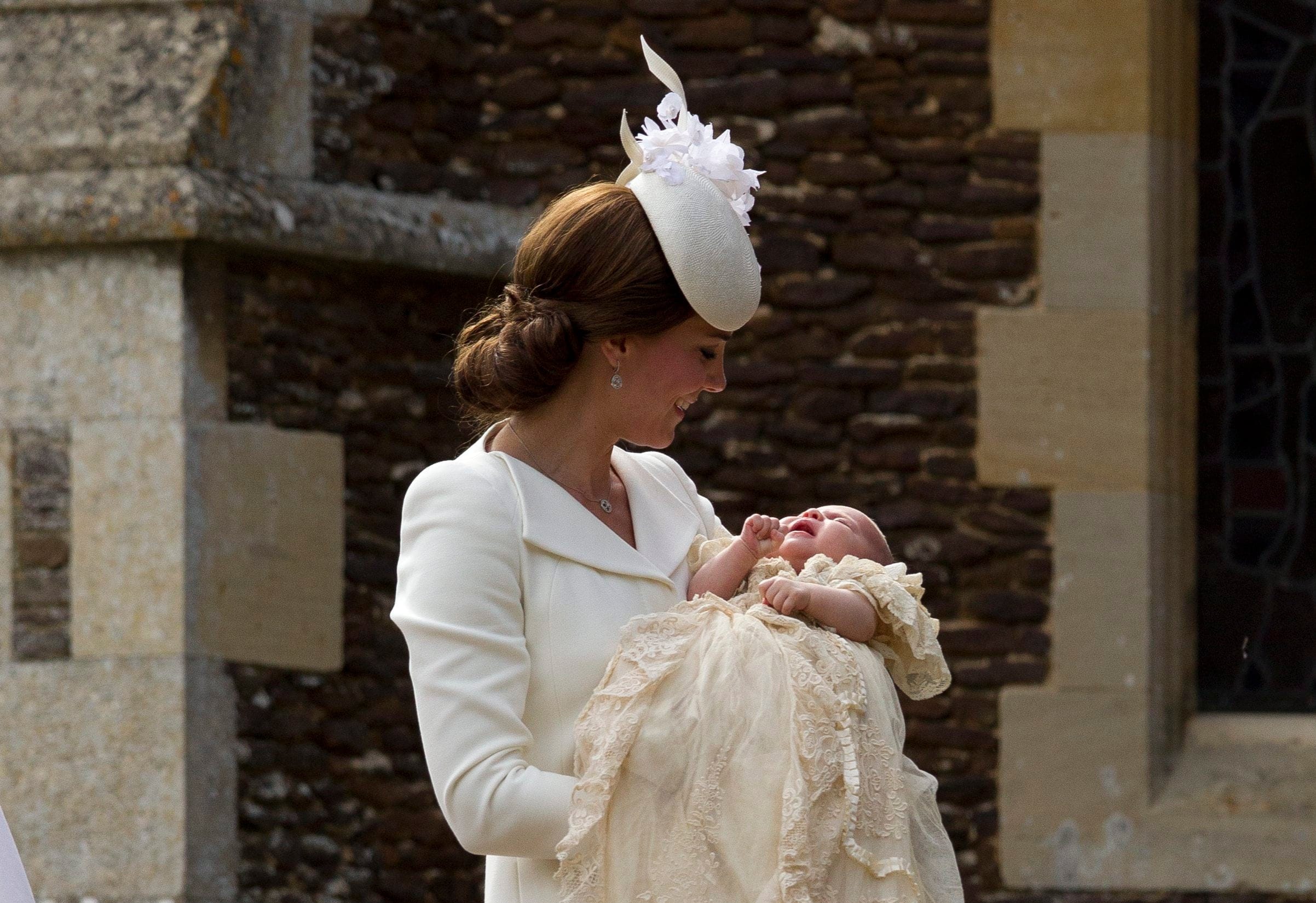 Britain's Kate the Duchess of Cambridge carries Princess Charlotte after taking her out of a pram as they arrive for Charlotte's Christening at St. Mary Magdalene Church in Sandringham, England, Sunday, July 5, 2015. (AP Photo/Matt Dunham, Pool)