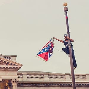 Bree Newsome takes down the Confederate Flag from a pole at the Statehouse in Columbia, South Carolina, June 27, 2015. Newsome was later arrested for her action. REUTERS/Adam Anderson Photo TPX IMAGES OF THE DAY NO SALES. NO ARCHIVES. FOR EDITORIAL USE ONLY. NOT FOR SALE FOR MARKETING OR ADVERTISING CAMPAIGNS. MANDATORY CREDIT. Adam Anderson/Reuters