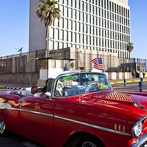 (150720) -- HAVANA, July 20, 2015 (Xinhua) -- A tourist from California waves a U.S. national flag inside a vintage American car near the U.S. Embassy in Havana, Cuba, on July 20, 2015. Cuba and the United States reopened their respective embassies on Monday as part of their recent agreement to restored diplomatic relations. (Liu Bin/XINHUA-REA/Redux)