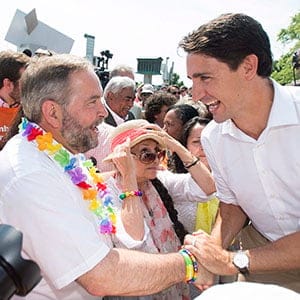 Liberal Leader Justin Trueau, right, greets NDP Leader Thomas Mulcair during a federal election campaign stop at the annual gay pride parade in Montreal, Sunday, August 16, 2015. THE CANADIAN PRESS/Graham Hughes