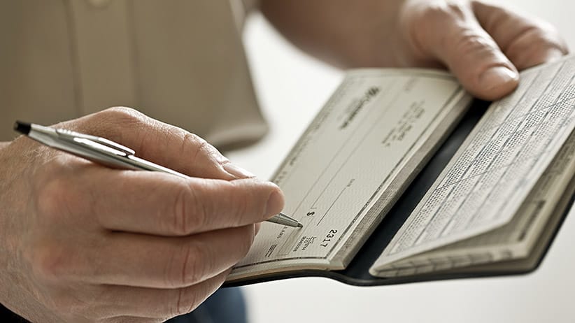 A man holding a cheque book. Getty Images