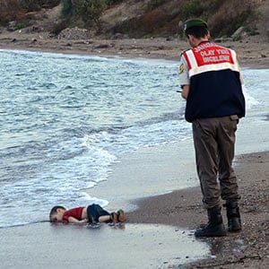 ADDS IDENTIFICATION OF CHILD Paramilitary police officers investigate the scene before carrying the lifeless body of Aylan Kurdi, 3, after a number of migrants died and a smaller number were reported missing after boats carrying them to the Greek island of Kos capsized, near the Turkish resort of Bodrum early Wednesday, Sept. 2, 2015. The family — Abdullah, his wife Rehan and their two boys, 3-year-old Aylan and 5-year-old Galip — embarked on the perilous boat journey only after their bid to move to Canada was rejected. The tides also washed up the bodies of Rehan and Galip on Turkey's Bodrum peninsula Wednesday, Abdullah survived the tragedy. AP