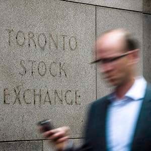 A man walks past a building in Toronto that used to house the Toronto Stock Exchange on August 18 2011. The Toronto stock market looked to open slightly higher as traders digest the latest data on U.S. retail sales and consumer sentiment. (Aaron Vincent Elkaim/CP)
