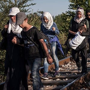 Gevgelija, Macedonia - A group of refugees and migrants on their way to the Gevgelijas train station, minutes after they have crossed the Greek - Macedonian border, on the 23rd of August 2015. Thousands of refugees (mostly coming from Syria) and migrants try every day to cross the Greek border to Macedonia (Fyrom), hoping to continue their journey to Central/North Europe and eventually reach countries like Germany, Great Britain and Sweden. (Socrates Baltagianni/Invision/Redux)