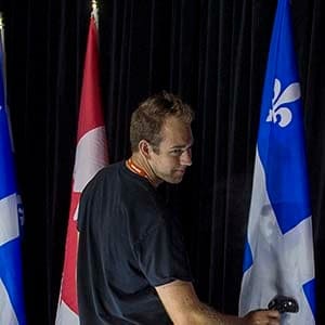 Technician Mike Sorowka steams wrinkles from the flags before NDP leader Tom Mulcair addresses supporters during a campaign stop in Montreal on Wednesday, Sept. 23, 2015. (Andrew Vaughan/CP)