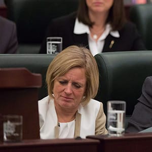 Premier Rachel Notley, left, Minister of Transportation and Minister of Infrastructure Brian Mason, centre, and Aboriginal Affairs minister Kathleen Ganley read over the 2015 provincial budget in Edmonton on Tuesday, Oct. 27, 2015. (Topher Seguin/CP)