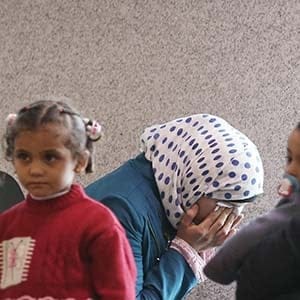 A Syrian woman refugee with her family shows tears while waiting at the immigration office of Incheon International Airport, South Korea, November 18 2015. (Shin Jun-hee/Yonhap/AP)