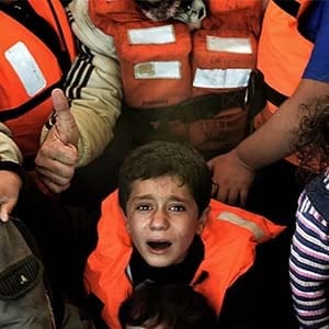 Syrian Kurdish refugees are rescued by Greek fishermen as the boat they had boarded sinks off the Greek island of Lesbos after crossing the Aegean sea from Turkey on October 30, 2015. (ARIS MESSINIS/AFP/GETTY IMAGES)