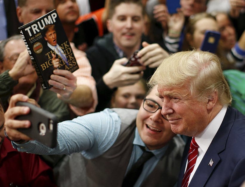 U.S. Republican presidential candidate Donald Trump takes a selfie with a supporter as he prepares to leave a campaign event in Anderson, South Carolina October 19, 2015. (Chris Keane/Reuters)