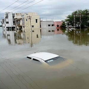 A car is submerged amidst water-logged houses in a rain-hit area of Chennai on November 17, 2015. India has deployed the army and air force to rescue flood-hit residents in the southern state of Tamil Nadu, where at least 71 people have died in around a week of torrential rains. (STR/AFP/Getty Images)
