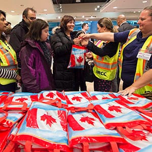 Newly-arrived Syrian refugee Anjilik Jaghlassian, centre, and her family receive winter clothes and other items at Pearson International airport, in Toronto, on Friday, Dec. 11, 2015. (Nathan Denette/CP)