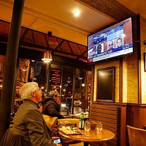People watch breaking news on the television in a cafe as police mobilize to a hostage situation at Porte de Vincennes on January 9, 2015 in Paris, France. According to reports at least five people have been taken hostage in a kosher deli in the Porte de Vincennes area of Paris. A huge manhunt for the two suspected gunmen in Wednesday's deadly attack on Charlie Hebdo magazine has entered its third day. (Richard Bord/Getty Images)