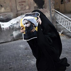 TOPSHOT - A Bahraini woman holds a poster bearing a portrait of prominent Shiite Muslim cleric Nimr al-Nimr during a protest against his execution by Saudi authorities, in the village of Jidhafs, west of the capital Manama on January 3, 2016. Iraq's top Shiite leaders condemned Saudi Arabia's execution of Nimr, warning ahead of protests that the killing was an injustice that could have serious consequences. MOHAMMED AL-SHAIKH/AFP/Getty Images