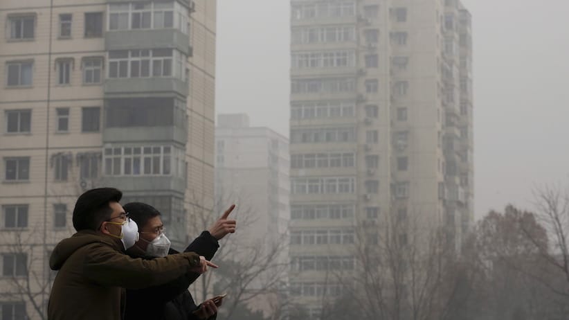 Men wearing protective masks talk on a street on a heavily polluted day in Beijing, December 25, 2015. REUTERS/Kim Kyung-Hoon - RTX2011F