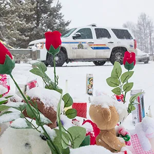 LA LOCHE, SASKATCHEWAN - JANUARY 23, 2016: Flowers are left as the RCMPA work on scene on the grounds of La Loche Community School in La Loche, SK that left 4 dead and 7 injured. A 17-year-old boy faces four counts of first-degree murder, seven counts of attempted murder and one count of unauthorized possession of a firearm in relation to a series of shooting in the northern Saskatchewan town of only 2300 people. ( Photos by Chris Bolin For Macleans Magazine)