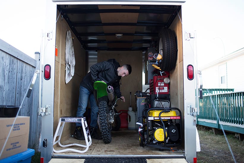 Brandon MacKay works on this motorbike in his trailer turned into a make shift garage, in Fort McMurray Alberta, November 14, 2015. Brandon MacKay was recently laid off from his job. (Photograph by Jason Franson)
