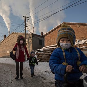 Chinese residents wear masks for protection as smoke billows from stacks in a neighborhood next to a coal fired power plant on November 26, 2015 in Shanxi, China. A history of heavy dependence on burning coal for energy has made China the source of nearly a third of the world's total carbon dioxide (CO2) emissions, the toxic pollutants widely cited by scientists and environmentalists as the primary cause of global warming. China's government has publicly set 2030 as a deadline to reach the country's emissions peak, and data suggest the country's coal consumption is already in decline. The governments of more than 190 countries are expected to sign an agreement in Paris to set targets on reducing carbon emissions in an attempt to forge a new global agreement on climate change. (Kevin Frayer/Getty Images)