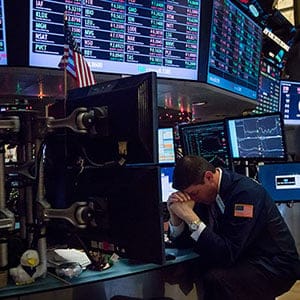 A trader bows his head while working on the floor of the New York Stock Exchange (NYSE) in New York, U.S., on Monday, Jan. 4, 2016. U.S. stocks tumbled to start 2016, falling to their lowest levels since mid-October, as a rout in Chinese equities renewed concern that an economic slowdown there will damp global growth. Photographer: Michael Nagle/Bloomberg/Getty Images