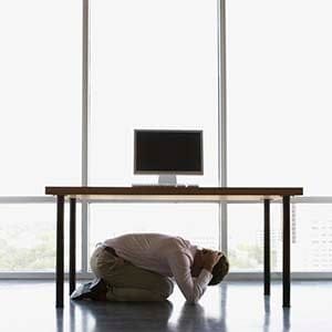 Businessman under a desk --- (Steve Hix/Somos Images/Corbis)