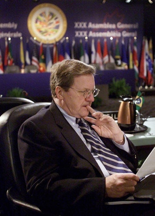 Canada's Foreign Minister Lloyd Axworthy reads prior to a session for delegates at the OAS Assembly in Windsor, Ont. Tuesday June 6, 2000. (CP PHOTO/Kevin Frayer)