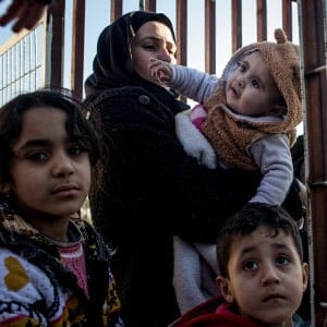 KILIS, TURKEY - FEBRUARY 08: A woman wanting to leave Turkey carries her child through the border gate as a small number of Syrian refugees were allowed to return to Syria at the closed Turkish border gate on February 8, 2016 in Kilis, Turkey. According to Turkish officials some 35,000 Syrian refugees have massed on the Syrian/Turkish border after fleeing Russian airstrikes and a regime offensive surrounding the city of Aleppo in northern Syria. Turkey's President Recep Tayyip Erdogan said Turkey would open it's doors" if necessary" (Chris McGrath/Getty Images)