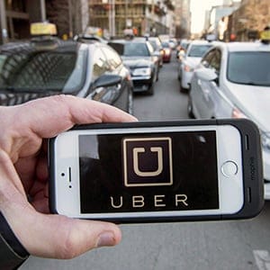 The Uber logo is seen in front of protesting taxi drivers at the Montreal courthouse, on February 2, 2016. Calgary city council has passed a bylaw that would allow for the operation of ride-sharing companies, but officials with Uber say the rules are too strict. (Ryan Remiorz/CP)