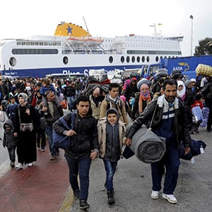 Refugees and migrants walk after disembarking from the passenger ferry Blue Star 1 at the port of Piraeus, near Athens, Greece, March 8, 2016. REUTERS/Michalis Karagiannis - RTS9S53. Michalis Karagiannis/Reuters