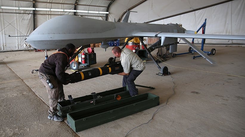 UNSPECIFIED, UNSPECIFIED - JANUARY 07: Contract workers load a Hellfire missile onto a U.S. Air Force MQ-1B Predator unmanned aerial vehicle (UAV), at a secret air base in the Persian Gulf region on January 7, 2016. The U.S. military and coalition forces use the base, located in an undisclosed location, to launch drone airstrikes against ISIL in Iraq and Syria, as well as to distribute cargo and transport troops supporting Operation Inherent Resolve. The Predators at the base are operated and maintained by the 46th Expeditionary Reconnaissance Squadron, currently attached to the 386th Air Expeditionary Wing. (John Moore/Getty Images)