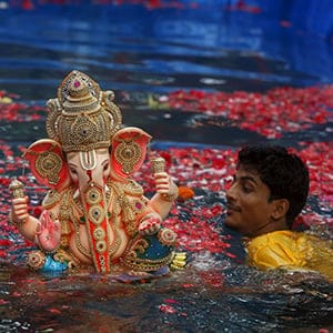 Volunteers carry an idol of the Hindu elephant god Ganesh, the deity of prosperity, in a pond for its immersion during the ten-day-long Ganesh Chaturthi festival in Mumbai, India, September 18, 2015. During the festival, idols are taken through the streets in a procession accompanied by dancing, singing and later immersed in a river or the sea in accordance with the Hindu faith. (Shailesh Andrade/Reuters)