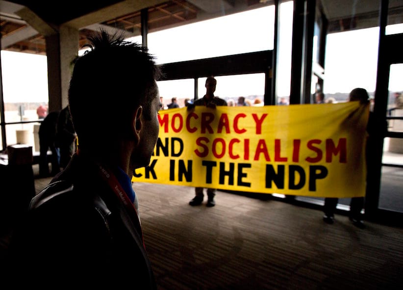 NDP delegates show a banner during the 2016 NDP Federal Convention in Edmonton Alta, on Sunday, April 10, 2016. THE CANADIAN PRESS/Jason Franson