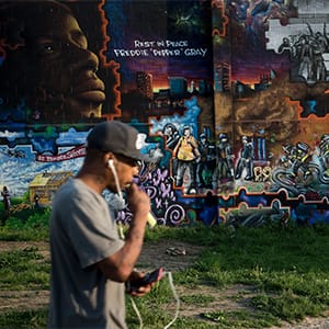 A man walks past a mural dedicated to Freddie Gray April 25, 2016 in Baltimore, Maryland, a year after the protests that were sparked by Gray's death in police custody. Baltimore agreed last year to pay a $6.4 million settlement with the family of Freddie Gray, whose death in custody sparked riots and looting in the gritty city located near the US capital Washington. (Brendan Smialowski/AFP/Getty)