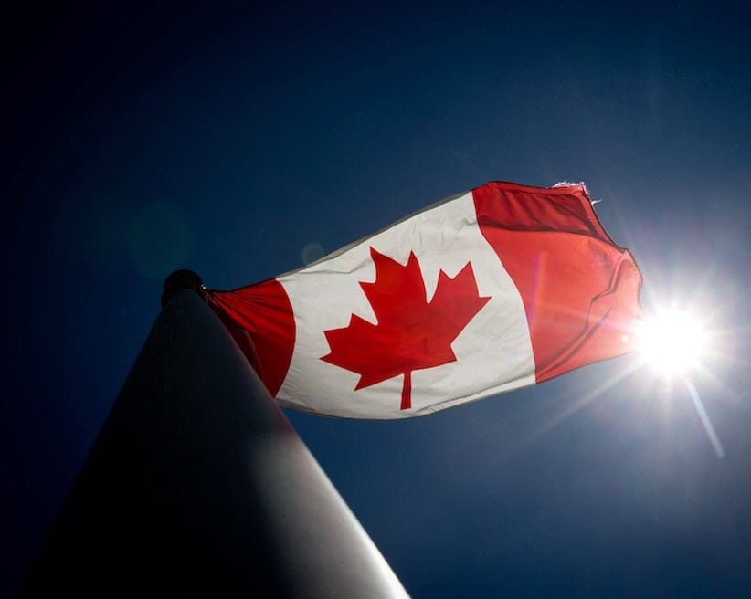 A Canadian flag flies in the wind at Granville Island in Vancouver, B.C., on Monday June 30, 2014. A Canadian flag was removed from a Manitoba advance polling station over the weekend because a worker felt it violated election rules. THE CANADIAN PRESS/Darryl Dyck