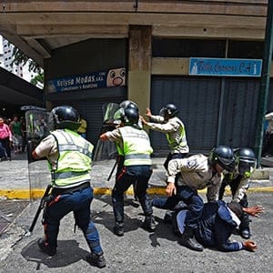 Security forces clash with people trying to reach Miraflores presidential palace to protest against the severe food and medicine shortages, in Caracas on June 2, 2016.
Venezuelans face long lines at supermarkets tightly guarded by nervous soldiers, bare shelves and soaring prices inside, a dysfunctional health care system short on basic medications and supplies, daily power cuts of four hours across most of the country, and a government that only operates two days a week to save electricity. (Juan Barreto/AFP/Getty Images)